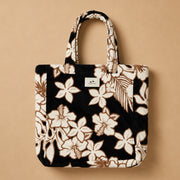 A black, cream and brown terry tote bag with a tropical floral print.