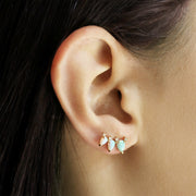 A crawler earring with three opal stones with four cz stones at the top.