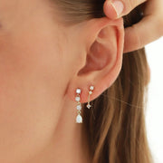 A pair of earrings with three cz stones and a teardrop shaped opal stone.