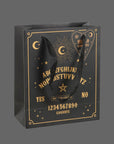 A black gift bag with gold ouija board design and black handles.