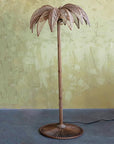 A brownish bronze metal palm tree shaped floor lamp.