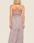A brown and white gingham dress with spaghetti strap details and a cross back.