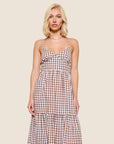 A brown and white gingham dress with spaghetti strap details and a cross back.