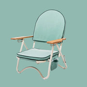 A green arched folding beach chair with wood arm rests and a zipper pocket in the back.