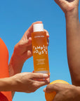 A bottle of orange body oil with white text that reads, 'Pamplemousse Replenishing Body Oil'.