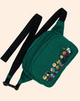 A dark green fanny pack with graphics of the characters of Peanuts and a black Baggu logo adjustable strap.
