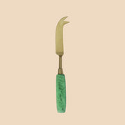 A green resin handle on a brass cheese knife.