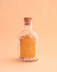 On a peachy background is a clear jar of wooden matches with a gold arched label on the front that reads, "Perfect Match".