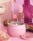 A small tin candle with a pink and gold detailed design that reads, 'Voluspa Perfectly Pink Yuzu Wicked'.