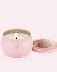 A small tin candle with a pink and gold detailed design that reads, 'Voluspa Perfectly Pink Yuzu Wicked'.