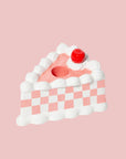 A pink and white checkered piece of cake candle holder with a hole in the center for the taper candle. Taper candles not included with purchase.