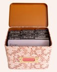 A metal recipe box with a pink daisy pattern with recipe cards and dividers.