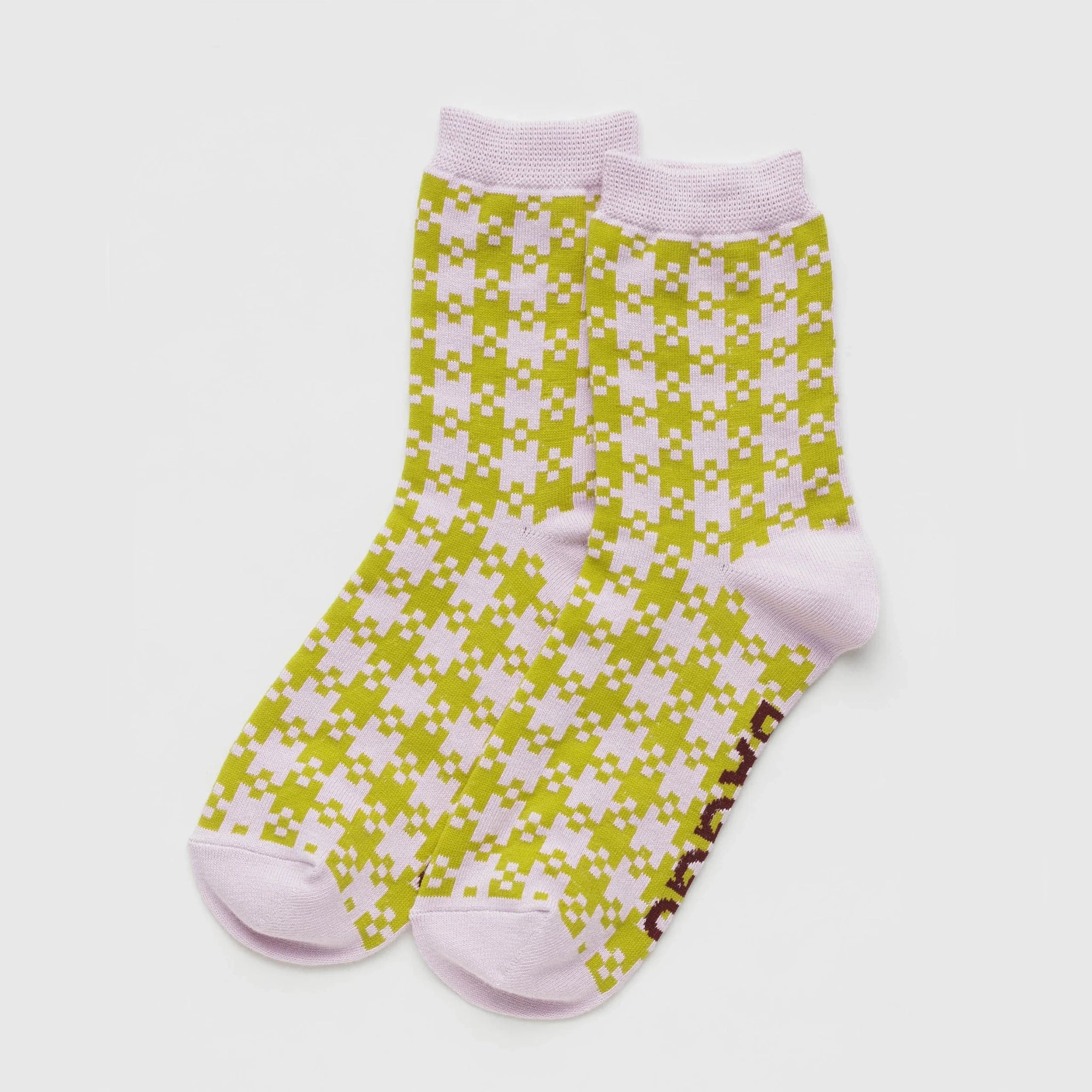 On a white background is a pair of pink and green gingham printed socks. 