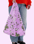 A pinkish purple nylon bag with a cactus and spike graphic print all over.