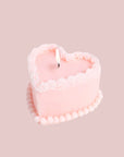 A pink, heart cake shaped candle.