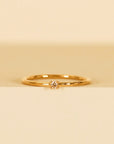 A gold dainty ring with a small champagne CZ stone in the center.