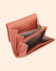 A light pinkish orange vegan leather wallet with a thin removable crossbody strap.