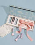 A gift box filled with three lip balms and a pink bow.