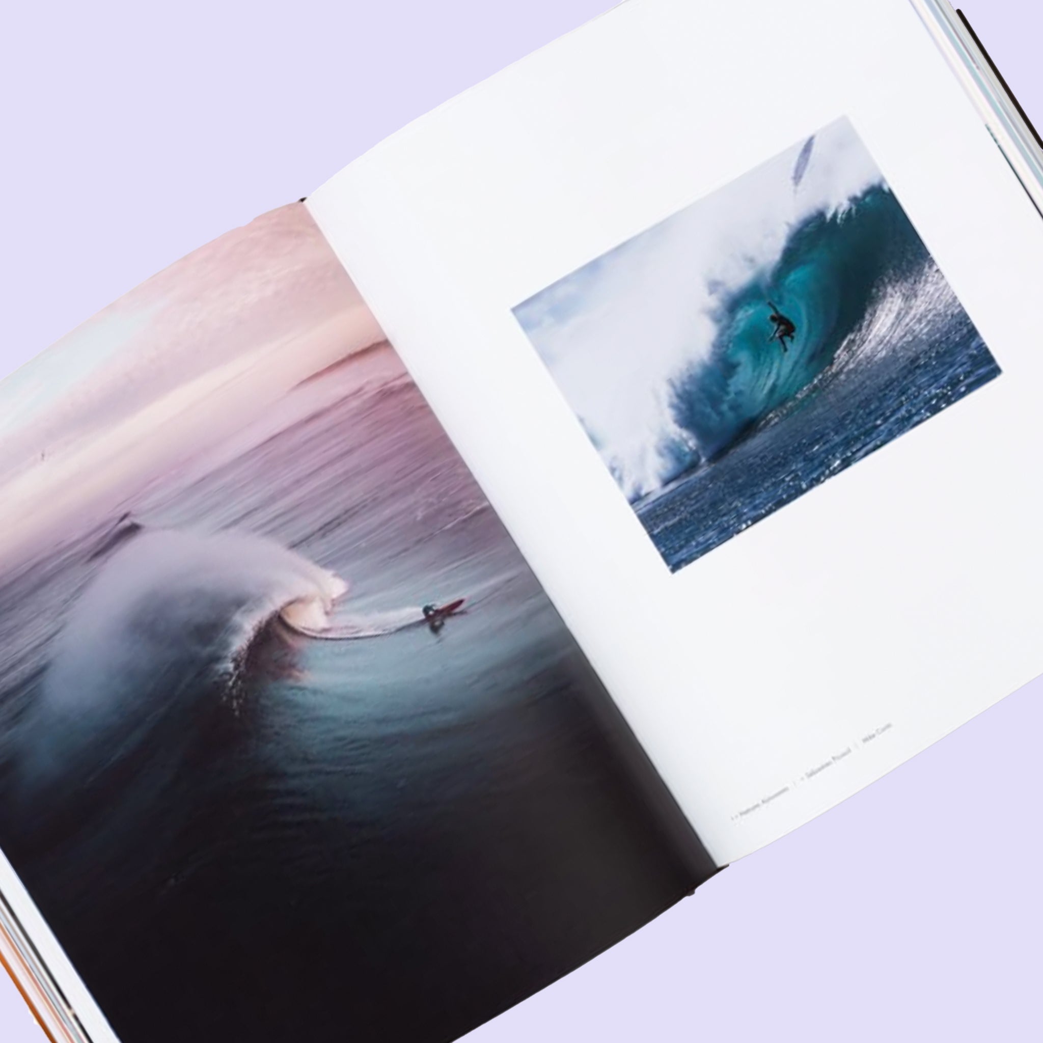 The book open to a page with beautiful photographs of surfers and waves.
