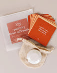 Cards with affirmations related to positivity in different shades of orange along with a shower steamer.