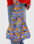 A purple reusable nylon bag with a charlie brown pumpkin patch pattern all over.