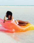A pink, orange and yellow ombre chaise lounge pool float.