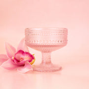 A light pink dot textured coupe drinking glass.