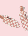 Two checkered hair clips with a white and pinkish terracotta checker print.