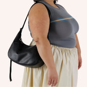 A recycled leather crescent bag shaped handbag.