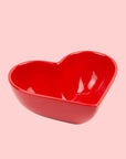 A red ceramic heart shaped bowl.