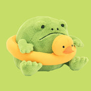 On a green background is a green frog toy with a duck ring wrapped around.