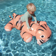 An orange and black striped tiger shaped ride on pool float for children.