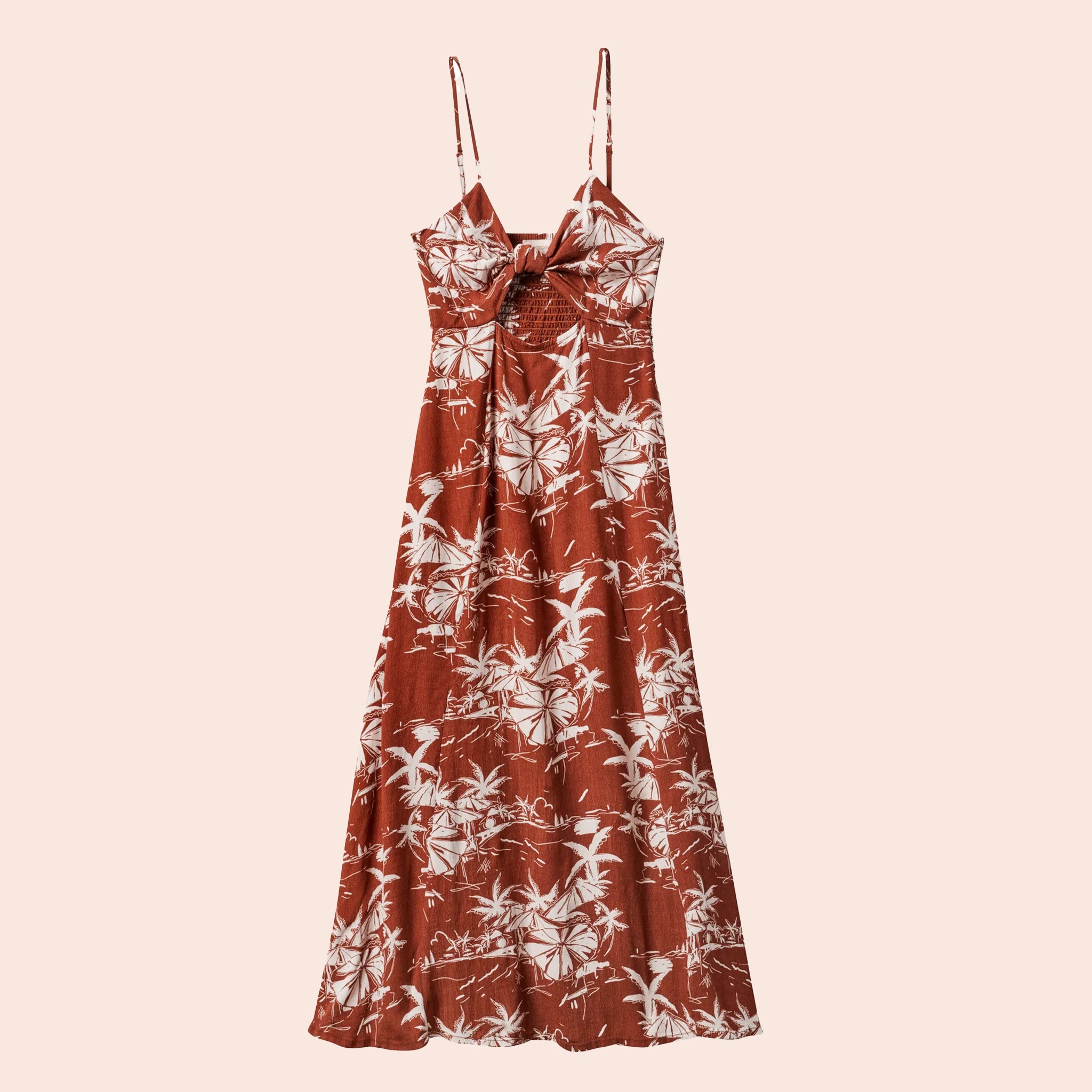 On a tan background is a rust colored dress with an ivory tropical print and a tie detail.