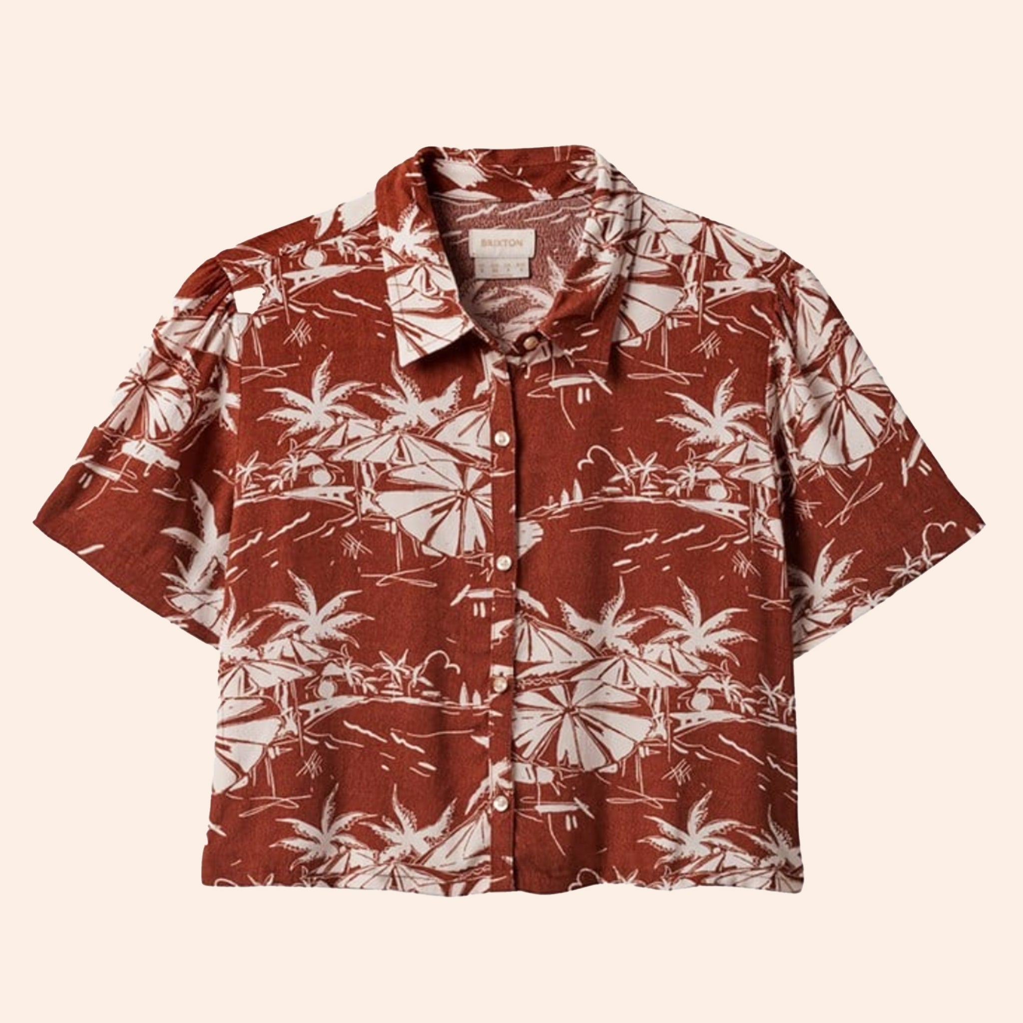A rust colored button up short sleeve shirt with an ivory tropical print.