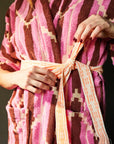 A pink kimono robe with a burnt orange and yellow chevron print.