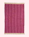 A pink chevron and striped print towel with an ivory tassel edge on two sides.