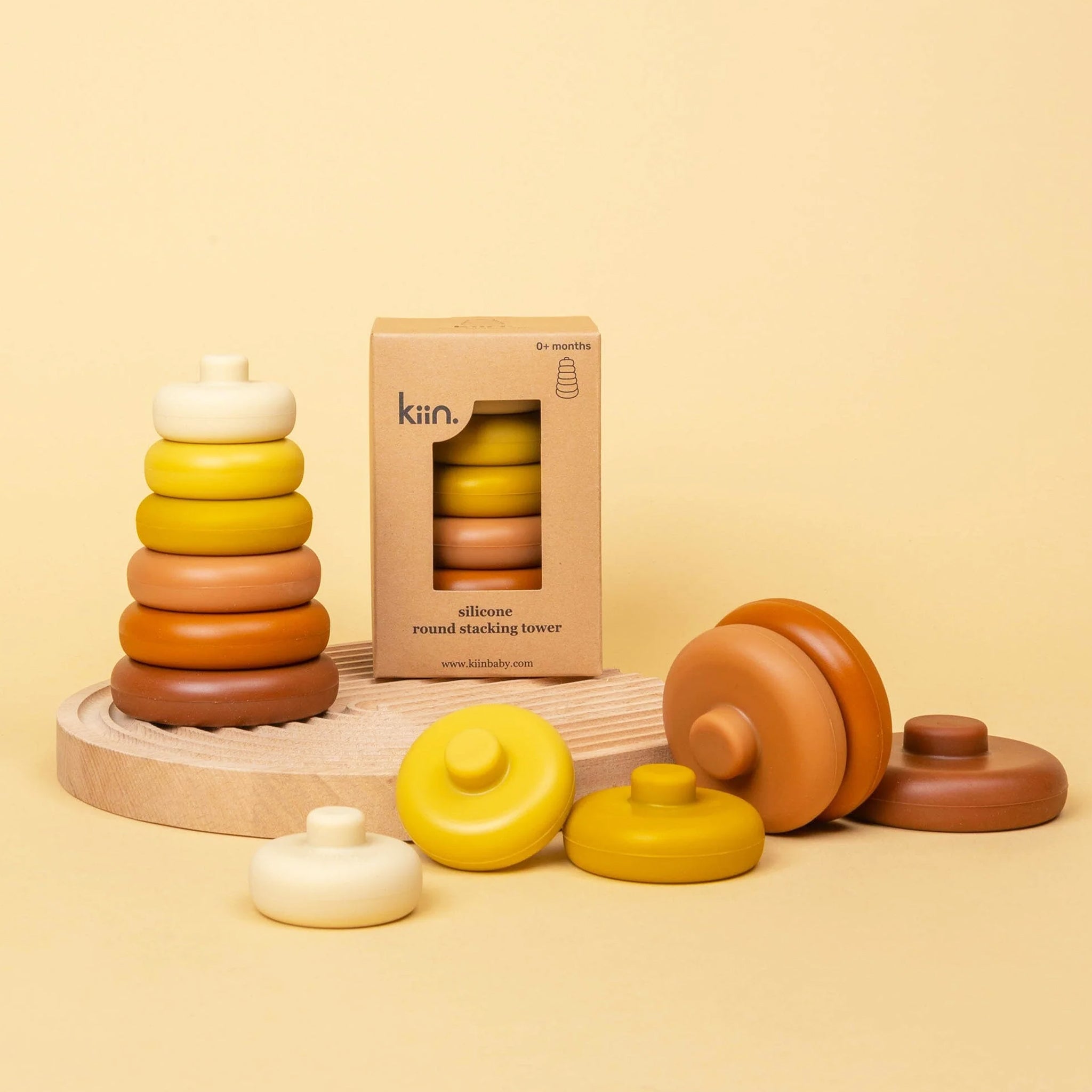 A children's silicone stacking toy in shades of yellow, orange and burnt orange. 
