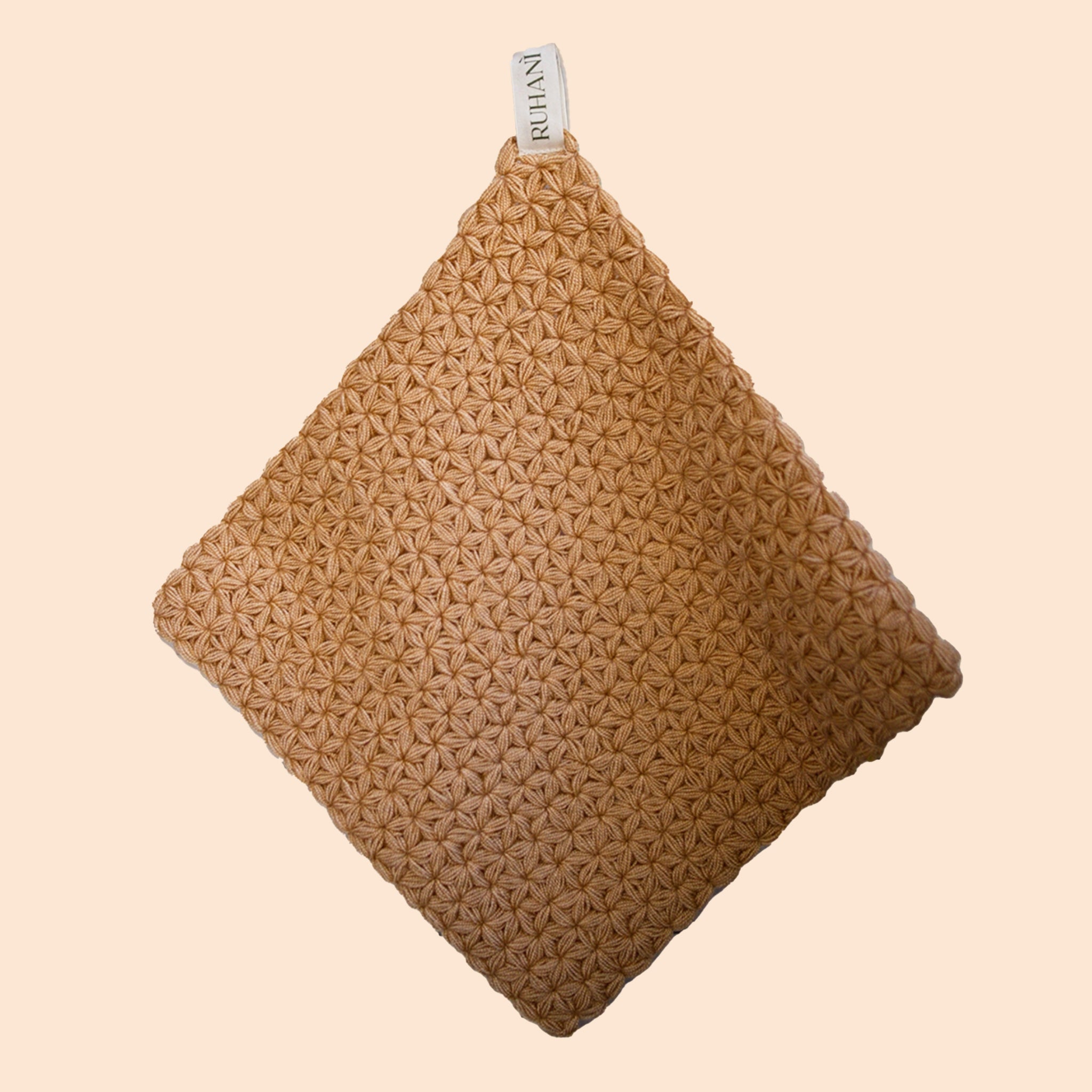 On a neutral background is a brownish tan woven Turkish wash cloth. 