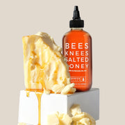 A squeeze bottle of honey with text on the front that reads, 'Bees Knees Salted Honey'.