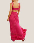 A hot pink maxi dress with a ruffle detail with a v-neckline with a bandeau style piece underneath.