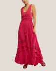 A hot pink maxi dress with a ruffle detail with a v-neckline with a bandeau style piece underneath.
