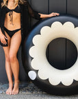 A black and white scalloped pool tube float.