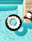 A black and white scalloped pool tube float.