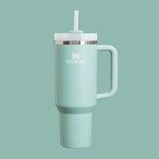 A light blueish green water bottle with a straw.