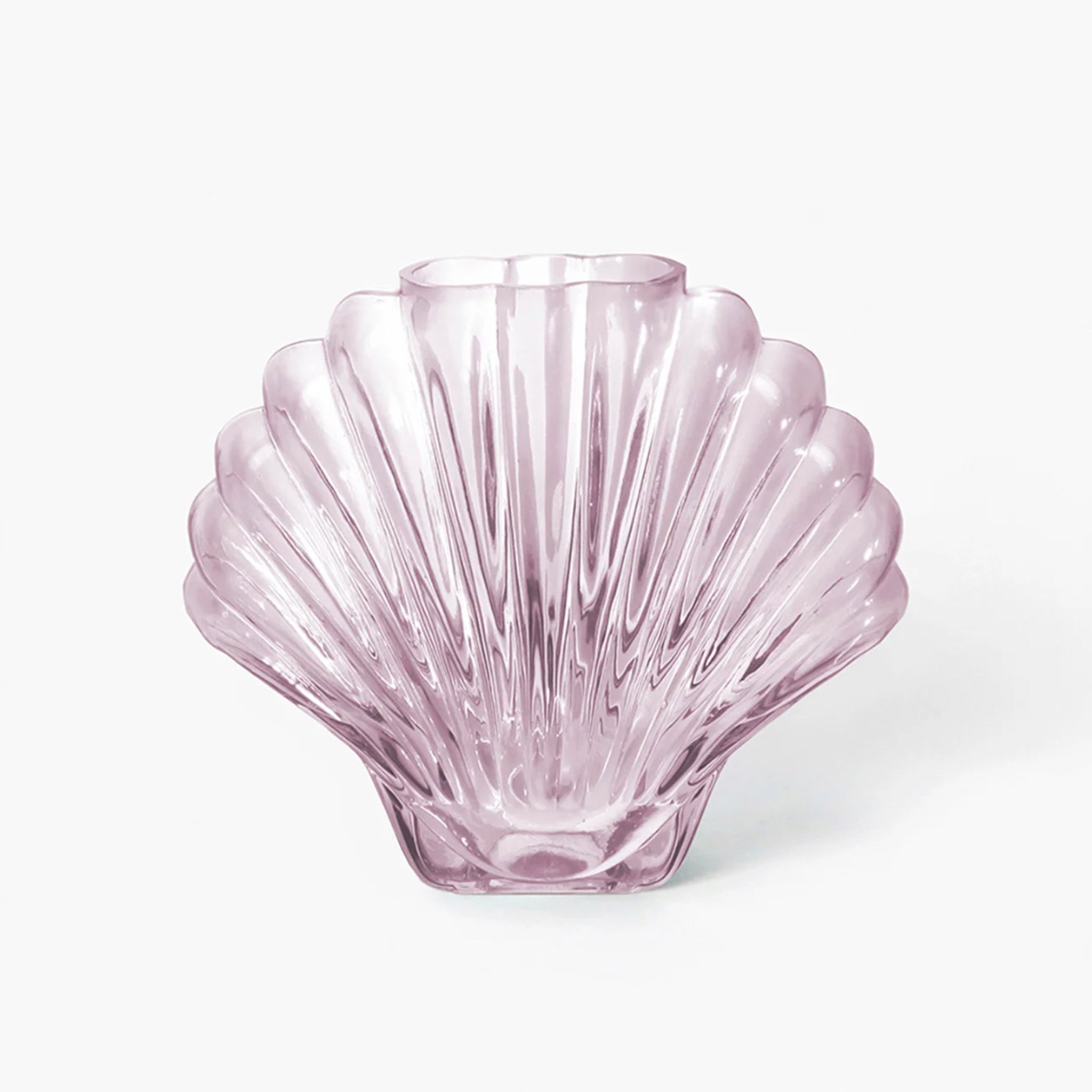 On a white background is a light pink glass, shell shaped vase. 