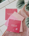 Different tones of pink cards that each have an uplifting affirmation on them for you to read and stick on the walls of your shower.