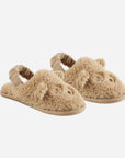 A pair of fuzzy brown slippers with a bear face design on the front and a strap on the back.