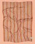 A burnt orange and white striped kitchen towel.