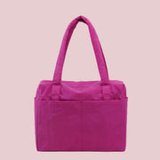 A hot pink nylon carry on tote bag.