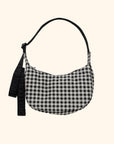 A small crescent shaped nylon back with a black and white gingham print and an adjustable strap.